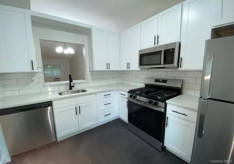 Beautifully just renovated eat in kitchen featuring lots white shaker cabinetry with dark hardware, quartz counters, stainless steel appliances, subway tile backsplash, and pretty tile floor. Beautifully just renovated eat in kitchen featuring lots white shaker cabinetry with dark hardware, quartz counters, stainless steel appliances, subway tile backsplash, and pretty tile floor.