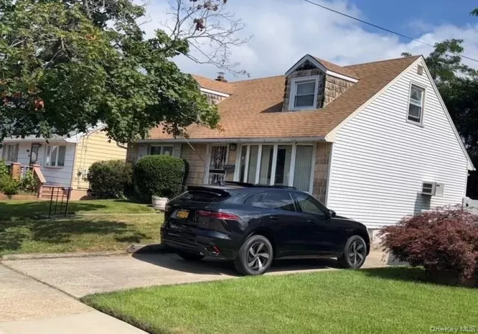 Cape cod home with a front lawn and a shingled roof Cape cod home with a front lawn and a shingled roof