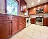 Kitchen with stainless steel appliances, washer and clothes dryer, light tile patterned floors, decorative backsplash, and light stone countertops Kitchen with stainless steel appliances, washer and clothes dryer, light tile patterned floors, decorative backsplash, and light stone countertops