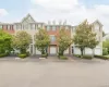 Townhome exterior featuring a dormer roofline, red brick accents. Townhome exterior featuring a dormer roofline, red brick accents.