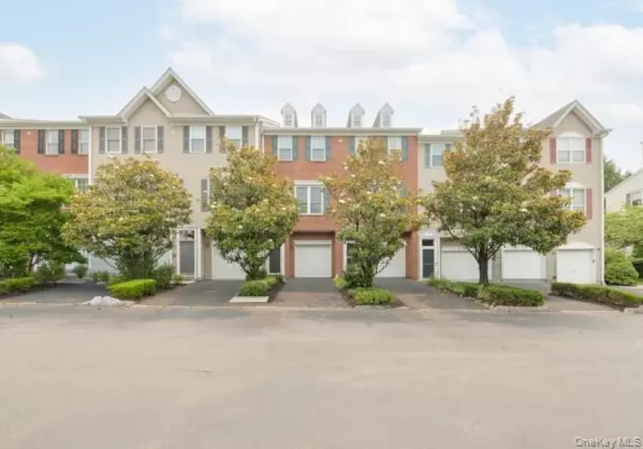 Townhome exterior featuring a dormer roofline, red brick accents. Townhome exterior featuring a dormer roofline, red brick accents.