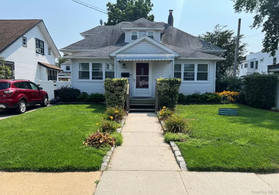 Front exterior featuring white siding, a prominent dormer, and a covered entry Front exterior featuring white siding, a prominent dormer, and a covered entry