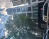 Modern multi-story building featuring a sleek facade, large windows, and a prominent treetop Modern multi-story building featuring a sleek facade, large windows, and a prominent treetop