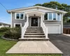Exterior featuring gray siding, a covered entry porch, a bay window, and an attached garage with a white door. Exterior featuring gray siding, a covered entry porch, a bay window, and an attached garage with a white door.