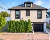 Two-story residence featuring a white stucco exterior and dark window trim Two-story residence featuring a white stucco exterior and dark window trim