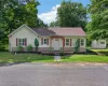 Cream vinyl siding exterior with red shutters, a covered entry, and a gravel walkway Cream vinyl siding exterior with red shutters, a covered entry, and a gravel walkway