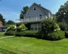 View of front facade with a gambrel roof, a chimney, and a front lawn View of front facade with a gambrel roof, a chimney, and a front lawn