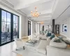 Living area featuring a notable chandelier, baseboards, beamed ceiling, and crown molding Living area featuring a notable chandelier, baseboards, beamed ceiling, and crown molding
