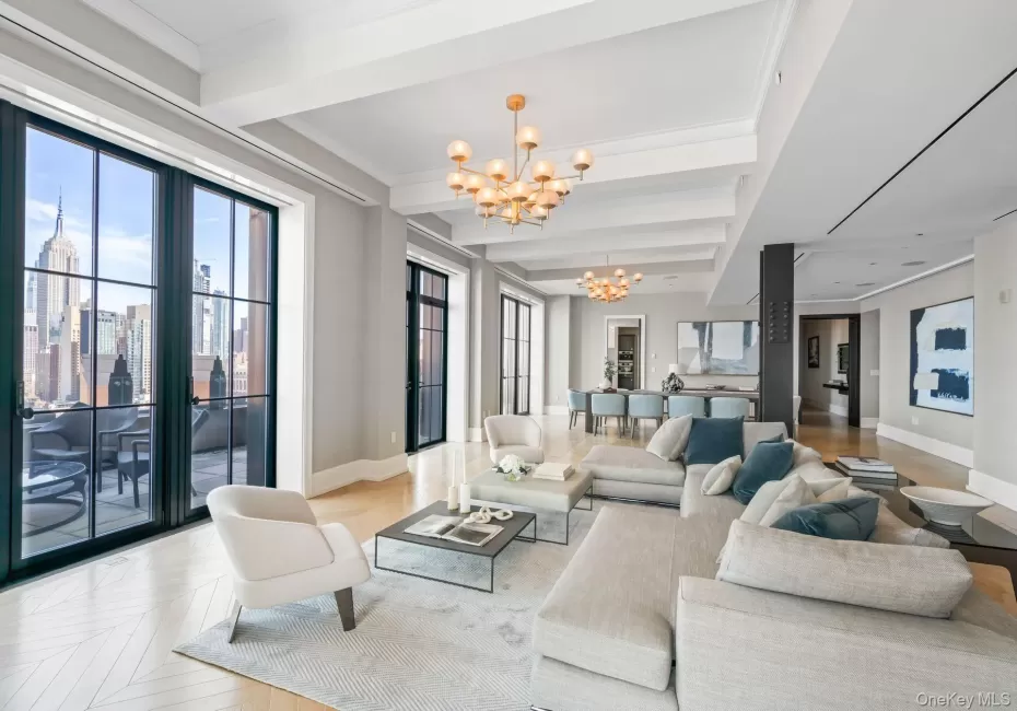 Living area featuring a notable chandelier, baseboards, beamed ceiling, and crown molding Living area featuring a notable chandelier, baseboards, beamed ceiling, and crown molding