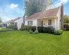 Front exterior featuring siding, a covered porch, a prominent chimney, and a landscaped front yard with shrubs Front exterior featuring siding, a covered porch, a prominent chimney, and a landscaped front yard with shrubs