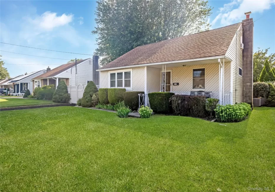 Front exterior featuring siding, a covered porch, a prominent chimney, and a landscaped front yard with shrubs Front exterior featuring siding, a covered porch, a prominent chimney, and a landscaped front yard with shrubs