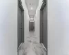 Corridor featuring light marble finish flooring, baseboards, and recessed lighting Corridor featuring light marble finish flooring, baseboards, and recessed lighting