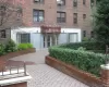 Brick facade building featuring a curved entrance awning, and a paved entry path Brick facade building featuring a curved entrance awning, and a paved entry path