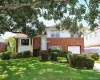 Brick and siding exterior with a garage door, front entry, bay window, and manicured landscaping Brick and siding exterior with a garage door, front entry, bay window, and manicured landscaping