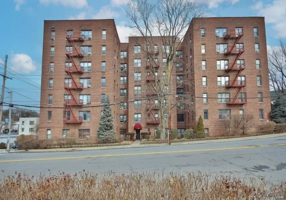 Brick multi-story building featuring multiple windows and exterior fire escapes Brick multi-story building featuring multiple windows and exterior fire escapes