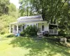 View of front of home with a porch, a chimney, and a front yard View of front of home with a porch, a chimney, and a front yard