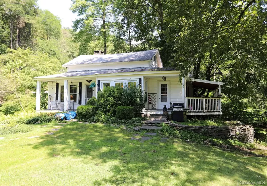 View of front of home with a porch, a chimney, and a front yard View of front of home with a porch, a chimney, and a front yard