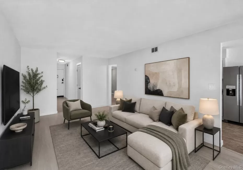 Bright living area featuring light-toned wood-finish flooring and neutral wall tones Bright living area featuring light-toned wood-finish flooring and neutral wall tones