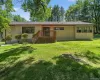 Front of property featuring a lawn and a deck Front of property featuring a lawn and a deck