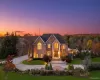View of front facade with a yard, curved driveway, and brick siding View of front facade with a yard, curved driveway, and brick siding