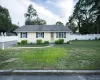 Single-story residence with light-colored siding, dark shutters, and decorative window grilles Single-story residence with light-colored siding, dark shutters, and decorative window grilles