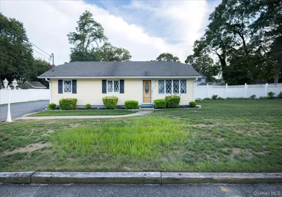 Single-story residence with light-colored siding, dark shutters, and decorative window grilles Single-story residence with light-colored siding, dark shutters, and decorative window grilles