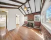 Unfurnished living room with light wood-style floors, brick wall, a wood stove, and a ceiling fan Unfurnished living room with light wood-style floors, brick wall, a wood stove, and a ceiling fan