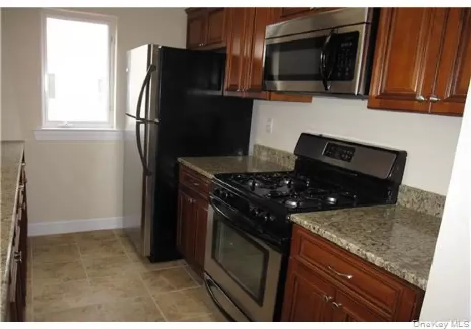 Beautiful galley kitchen has wood cabinets, granite counters, stainless steel appliances and a pantry Beautiful galley kitchen has wood cabinets, granite counters, stainless steel appliances and a pantry