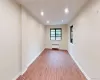 Unfurnished room with radiator heating unit, wood finished floors, recessed lighting, and baseboards Unfurnished room with radiator heating unit, wood finished floors, recessed lighting, and baseboards
