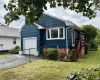 Blue shake siding exterior with white trim, a single-car garage, and a red brick foundation Blue shake siding exterior with white trim, a single-car garage, and a red brick foundation