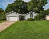 Grey vinyl siding exterior with a concrete driveway, attached garage, and a semicircular arched window Grey vinyl siding exterior with a concrete driveway, attached garage, and a semicircular arched window