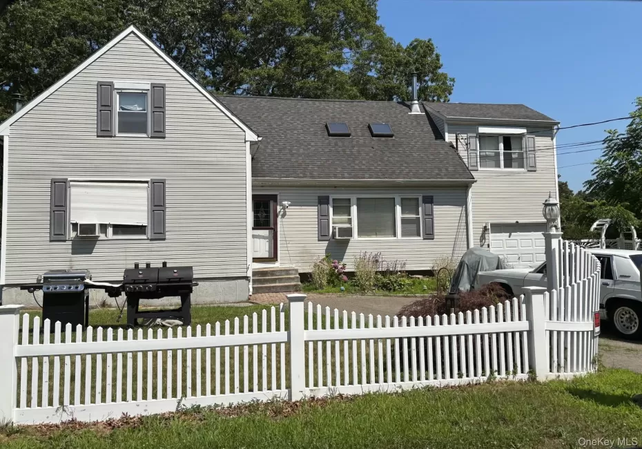 Traditional-style home featuring a shingled roof and an attached garage Traditional-style home featuring a shingled roof and an attached garage