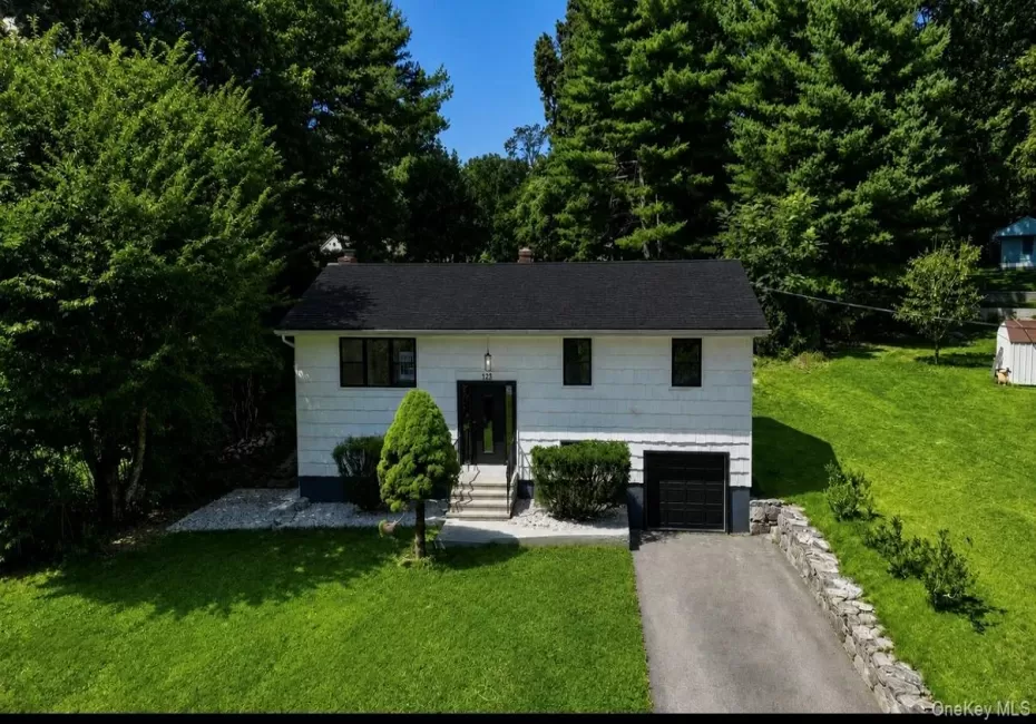 White siding exterior with a dark shingle roof, integrated garage, and concrete driveway White siding exterior with a dark shingle roof, integrated garage, and concrete driveway