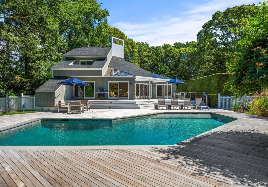 View of pool, a wood deck and home View of pool, a wood deck and home
