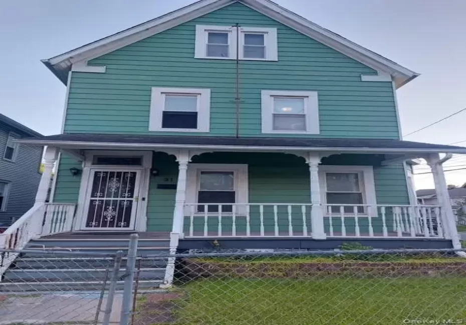 Two-story residence with a covered front porch, white railing, and exterior lighting Two-story residence with a covered front porch, white railing, and exterior lighting
