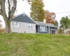 View of front facade featuring a front lawn, a garage, a chimney, and brick siding View of front facade featuring a front lawn, a garage, a chimney, and brick siding