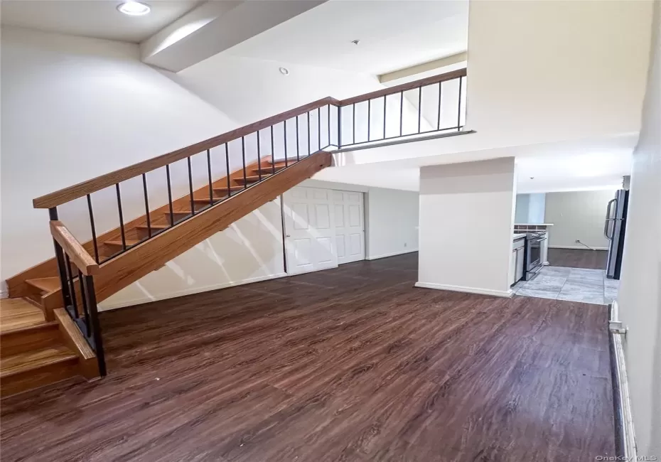 Dramatic foyer featuring tall ceilings, wood flooring, and an open staircase to the loft level. Dramatic foyer featuring tall ceilings, wood flooring, and an open staircase to the loft level.