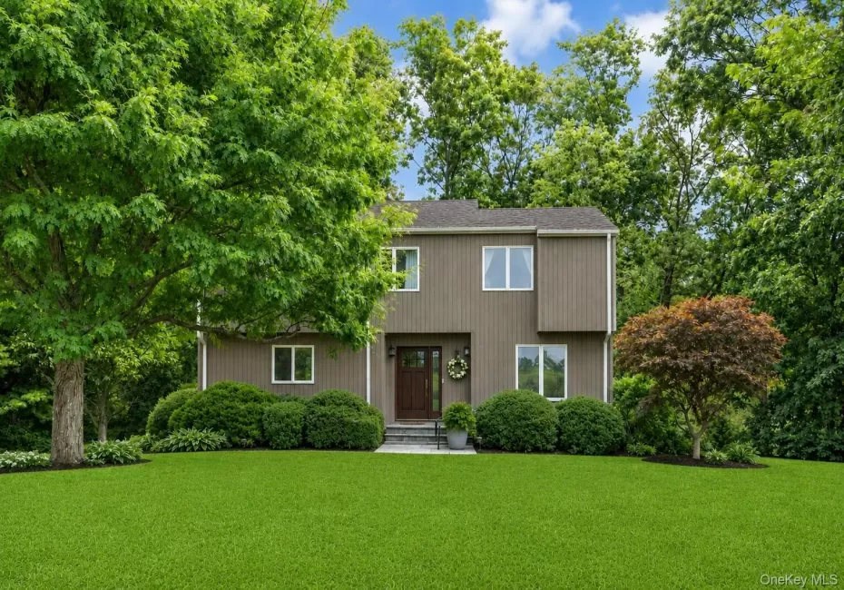 Transitional style home, exterior with brown wood siding, white-framed windows, and welcoming wood entry door Transitional style home, exterior with brown wood siding, white-framed windows, and welcoming wood entry door