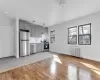 Kitchen featuring gray cabinetry, appliances with stainless steel finishes, light wood-type flooring, decorative backsplash, and radiator Kitchen featuring gray cabinetry, appliances with stainless steel finishes, light wood-type flooring, decorative backsplash, and radiator