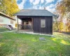 View of outbuilding featuring a lawn View of outbuilding featuring a lawn