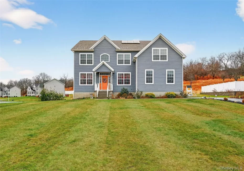 View of front of property with a front lawn and solar panels View of front of property with a front lawn and solar panels