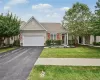 Siding exterior with stone accents, attached two-car garage, concrete walkway, and landscaped garden beds Siding exterior with stone accents, attached two-car garage, concrete walkway, and landscaped garden beds