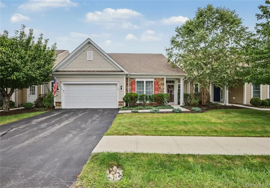 Siding exterior with stone accents, attached two-car garage, concrete walkway, and landscaped garden beds Siding exterior with stone accents, attached two-car garage, concrete walkway, and landscaped garden beds