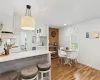 Kitchen with white cabinets, tasteful backsplash, hanging light fixtures, a peninsula, and light countertops Kitchen with white cabinets, tasteful backsplash, hanging light fixtures, a peninsula, and light countertops