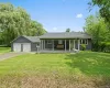 Ranch-style home featuring a porch, a front yard, a garage, driveway, and a shingled roof Ranch-style home featuring a porch, a front yard, a garage, driveway, and a shingled roof