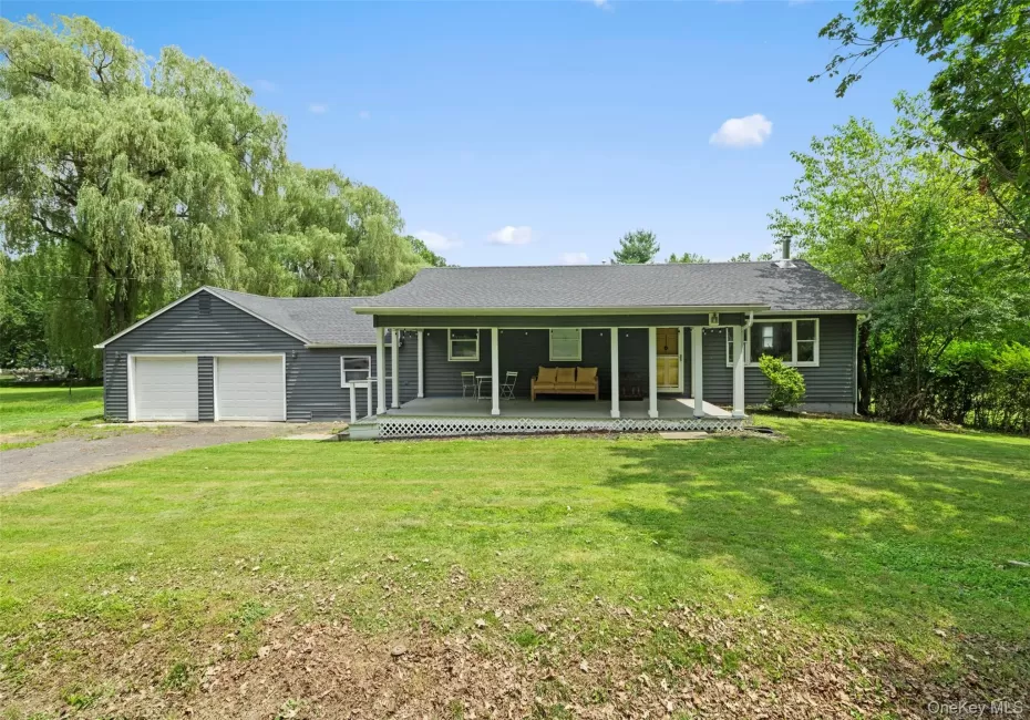 Ranch-style home featuring a porch, a front yard, a garage, driveway, and a shingled roof Ranch-style home featuring a porch, a front yard, a garage, driveway, and a shingled roof