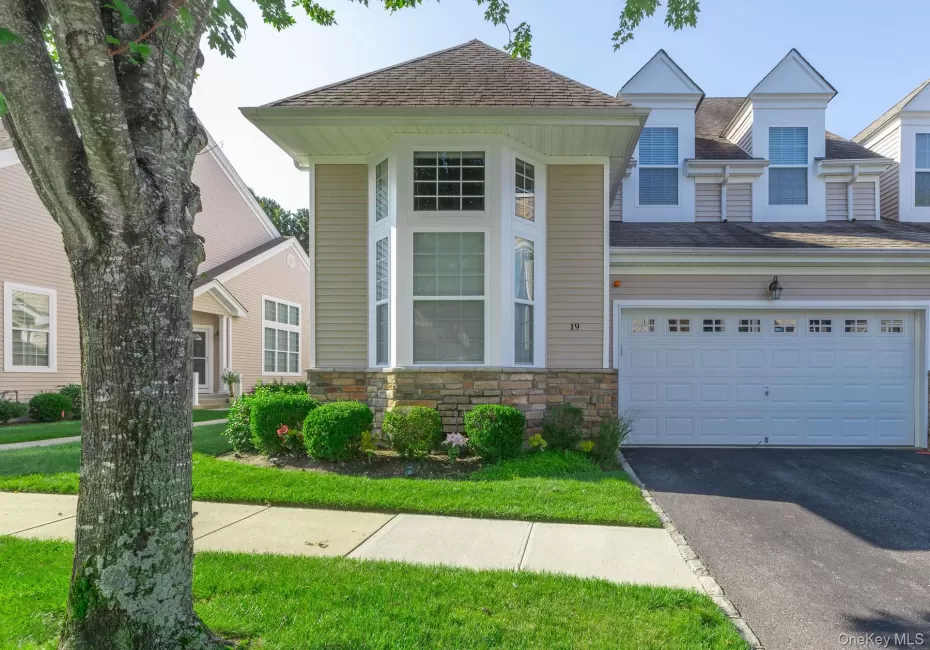 Exterior Street view featuring bay windows, stone facade accents, and a newly paved driveway Exterior Street view featuring bay windows, stone facade accents, and a newly paved driveway