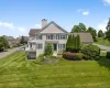Rear view of house with a chimney and a yard Rear view of house with a chimney and a yard