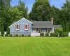 Single-story residence featuring blue cedar shingles , white trim, and red shutters Single-story residence featuring blue cedar shingles , white trim, and red shutters