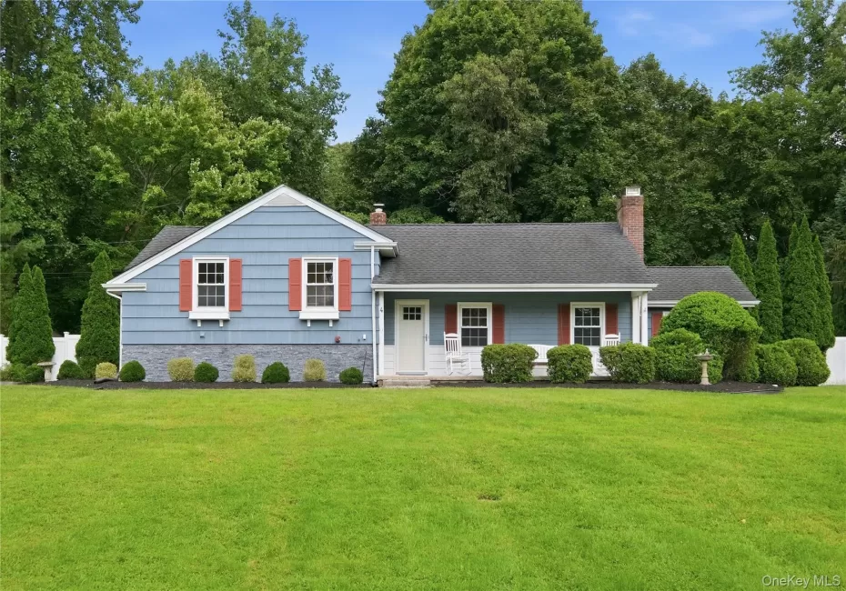 Single-story residence featuring blue cedar shingles , white trim, and red shutters Single-story residence featuring blue cedar shingles , white trim, and red shutters
